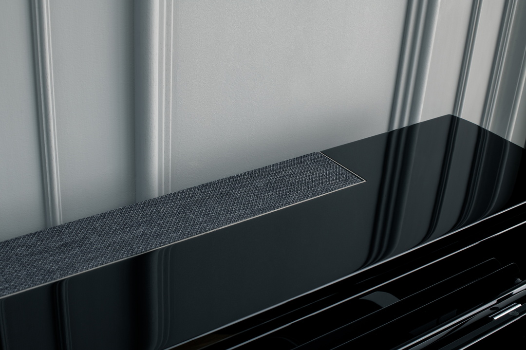Detail eines schwarzen Kawai Hybridpianos vor einer Wand